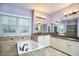 Spacious primary bathroom featuring a soaking tub, double sinks, granite countertops, and modern fixtures at 5612 Crossfield Dr, Raleigh, NC 27613