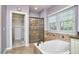 Bright primary bathroom with soaking tub, shower with glass door, and access to a large walk-in closet at 5612 Crossfield Dr, Raleigh, NC 27613