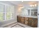 Bathroom featuring double vanity with granite countertop, tile floors, and large window at 5612 Crossfield Dr, Raleigh, NC 27613