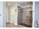 Modern tiled shower with glass door, built-in niche, and recessed lighting at 5612 Crossfield Dr, Raleigh, NC 27613