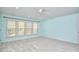 Light filled bedroom features neutral colored walls, carpet, and three wide windows at 5612 Crossfield Dr, Raleigh, NC 27613
