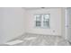 Light colored bedroom featuring a window, door and neutral walls and carpeting at 5612 Crossfield Dr, Raleigh, NC 27613