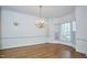 Formal dining room with chandelier lighting, bay window, hardwood floors, and classic decorative wall trim at 5612 Crossfield Dr, Raleigh, NC 27613