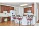 Well-lit kitchen with wood cabinets, stainless steel appliances, and breakfast bar with seating for a warm, inviting space at 5612 Crossfield Dr, Raleigh, NC 27613