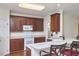 Bright kitchen with cherry cabinets, white countertops and appliances, and three stools at the breakfast bar at 5612 Crossfield Dr, Raleigh, NC 27613