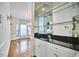 Wet bar with mirrored backsplash, glass shelves, dark countertop and white cabinets near the dining area at 5612 Crossfield Dr, Raleigh, NC 27613