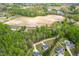 Expansive aerial view featuring a large field surrounded by lush trees and residential properties at 5989 Zacks Mill Rd, Angier, NC 27501