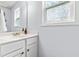 A sun-lit bathroom features a white vanity and a decorative window providing privacy and style at 5989 Zacks Mill Rd, Angier, NC 27501