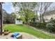 Landscaped backyard with shed, mature trees, brick firepit and green lawn at 6020 Jones Farm Rd, Wake Forest, NC 27587