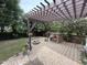 Landscaped backyard featuring a brick pizza oven, fire pit and a cozy pergola-covered seating area at 6020 Jones Farm Rd, Wake Forest, NC 27587