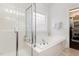 Bright bathroom featuring a soaking tub, glass shower, and linen closet at 6020 Jones Farm Rd, Wake Forest, NC 27587