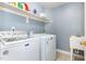 Well-lit laundry room featuring a washing machine, dryer, sink, and shelving for storage at 6020 Jones Farm Rd, Wake Forest, NC 27587