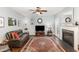 Comfortable living room featuring a fireplace, leather sofa, ceiling fan, and an area rug at 6020 Jones Farm Rd, Wake Forest, NC 27587