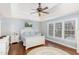 Comfortable main bedroom boasts tray ceiling, hardwood floors, a ceiling fan, and natural light at 6020 Jones Farm Rd, Wake Forest, NC 27587