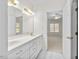 Bright bathroom featuring a double vanity, white cabinets, and a door to the bedroom at 615 Woodland Trl, Louisburg, NC 27549