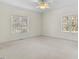 Spacious bedroom with carpet and two large windows, offering natural light and backyard views at 615 Woodland Trl, Louisburg, NC 27549