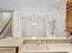 Bright kitchen with an undermount sink and view to the stairs and glass paneled doors at 615 Woodland Trl, Louisburg, NC 27549
