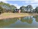 Beautiful home with a tranquil pond reflecting the property, enhanced by surrounding greenery at 615 Woodland Trl, Louisburg, NC 27549