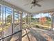 Screened-in porch featuring brick flooring, fan, and views of the surrounding landscape and lake at 615 Woodland Trl, Louisburg, NC 27549