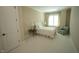 Well-lit bedroom with white bedding, a side table, and a comfortable chair at 620 Wade Ave # 206, Raleigh, NC 27605