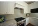 Well-equipped kitchen with white cabinets, stainless steel gas range, granite counters and decorative tile backsplash at 620 Wade Ave # 206, Raleigh, NC 27605