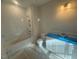 Bathroom with tile-surround bathtub, shower, and white vanity at 70 Valebrook Ct, Youngsville, NC 27596