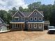 New two-story home featuring gray siding, white trim, a covered porch, and an attached garage on a spacious lot at 70 Valebrook Ct, Youngsville, NC 27596