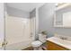Bathroom featuring a shower-tub combo, toilet, and vanity with a gray paint scheme at 708 Brye St, Durham, NC 27703