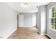 Bedroom featuring wood-look floors, neutral paint, and multiple doors with ample natural light at 708 Brye St, Durham, NC 27703