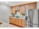 Basement kitchenette features granite counters, light wood cabinets, and a stainless steel refrigerator at 76501 Rice, Chapel Hill, NC 27517