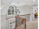 Upstairs landing with ornate chandelier and window seat offers a bright transition space at 76501 Rice, Chapel Hill, NC 27517
