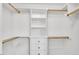 Bright walk-in closet features custom shelving, drawers and hanging rods for optimal organization at 76501 Rice, Chapel Hill, NC 27517