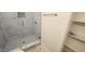 Shower stall with seamless glass doors and marble tile, along with shelving at 795 Terry Rd, Hurdle Mills, NC 27541