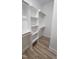 Walk in closet with white storage shelves and stylish wood flooring at 795 Terry Rd, Hurdle Mills, NC 27541
