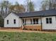 An eye-catching home exterior features a stylish porch, clean lines, and pristine curb appeal at 795 Terry Rd, Hurdle Mills, NC 27541