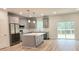 Well-lit modern kitchen features an island, stainless appliances, and sliding glass doors to deck at 795 Terry Rd, Hurdle Mills, NC 27541