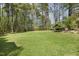 Lush, expansive backyard surrounded by mature trees, offering privacy and a serene environment at 8008 Hollander Pl, Raleigh, NC 27606
