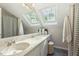 Bathroom features dual sinks, granite countertops, dark floor tiles, and two skylights for natural light at 8008 Hollander Pl, Raleigh, NC 27606