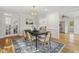 Dining room with hardwood floors, a modern chandelier, and a view into the kitchen at 8008 Hollander Pl, Raleigh, NC 27606