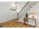Bright foyer featuring hardwood floors, staircase with iron spindles and a decorative light fixture at 8008 Hollander Pl, Raleigh, NC 27606