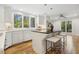 Bright kitchen with white cabinetry, a center island, hardwood floors and stainless steel appliances at 8008 Hollander Pl, Raleigh, NC 27606