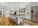 Stylish kitchen with stainless steel appliances, a center island with seating, and hardwood floors at 8008 Hollander Pl, Raleigh, NC 27606