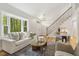 Inviting living room with a large bay window, hardwood floors, and a modern light fixture at 8008 Hollander Pl, Raleigh, NC 27606