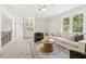 The home's living room features neutral colors, large windows, and a built-in cabinet with glass doors at 8008 Hollander Pl, Raleigh, NC 27606