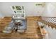Bright living room with hardwood floors, white sofa, chairs and a staircase featuring iron railing at 8008 Hollander Pl, Raleigh, NC 27606