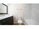 Modern bathroom featuring a marble countertop, black vanity, and tiled shower and bathtub at 909 Windcrest Rd, Durham, NC 27713