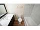 Bright bathroom featuring a black vanity with a marble countertop and tub-shower with tile surround at 909 Windcrest Rd, Durham, NC 27713