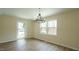Bright dining room features modern chandelier, wood floors, and sunlit windows at 909 Windcrest Rd, Durham, NC 27713