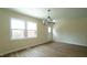 Bright dining room with a modern chandelier and wood-look floors at 909 Windcrest Rd, Durham, NC 27713