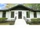 Close up of the home's entrance with black door, black trim, and well-manicured landscaping at 909 Windcrest Rd, Durham, NC 27713
